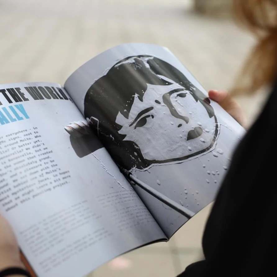 The Benzorella face printed large in an open magazine
