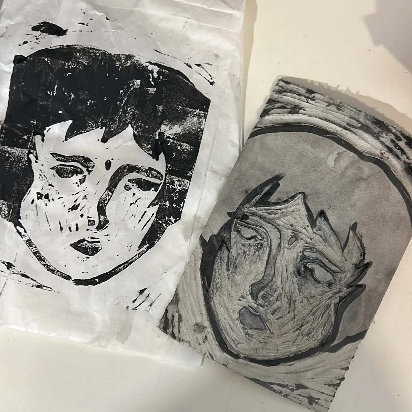 Two hand-printed Benzorella faces on white fabric