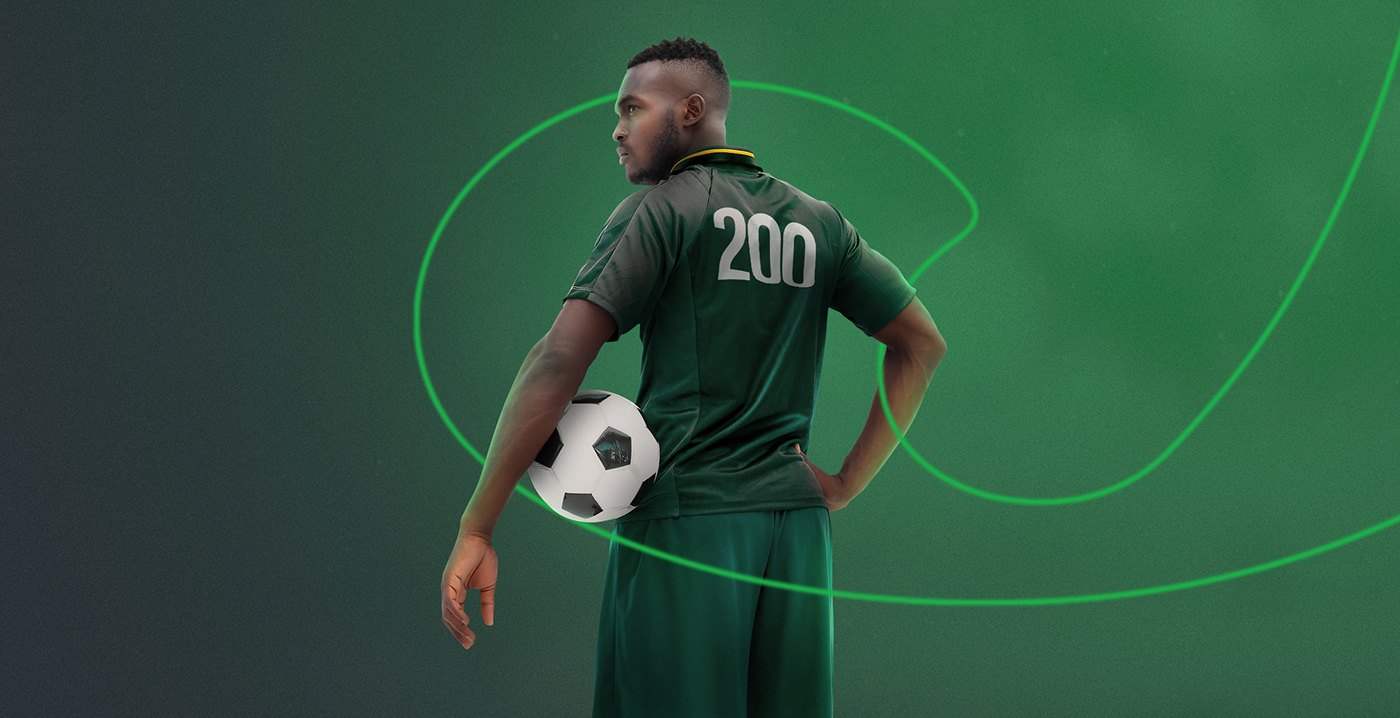 A footballer seen from behind in a green number 200 kit, on dark green with glowing circular lines