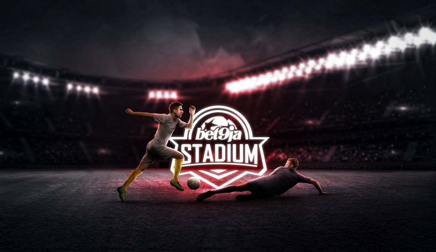 A player sliding on a wet pitch in a floodlit stadium at night